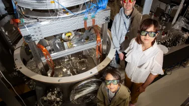 Physicists in lab wearing PPE