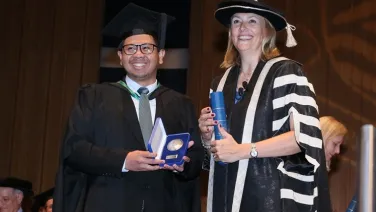 Hilman Fathoni receiving his University Medal from Naomi Flutter, Pro-Vice-Chancellor