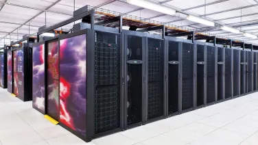 A row of large server cabinets decorated with colorful nebula imagery in a modern data center.