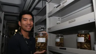 Man holds jar with snake specimen inside